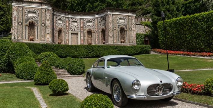 Old Maserati on lawn of nice residence
