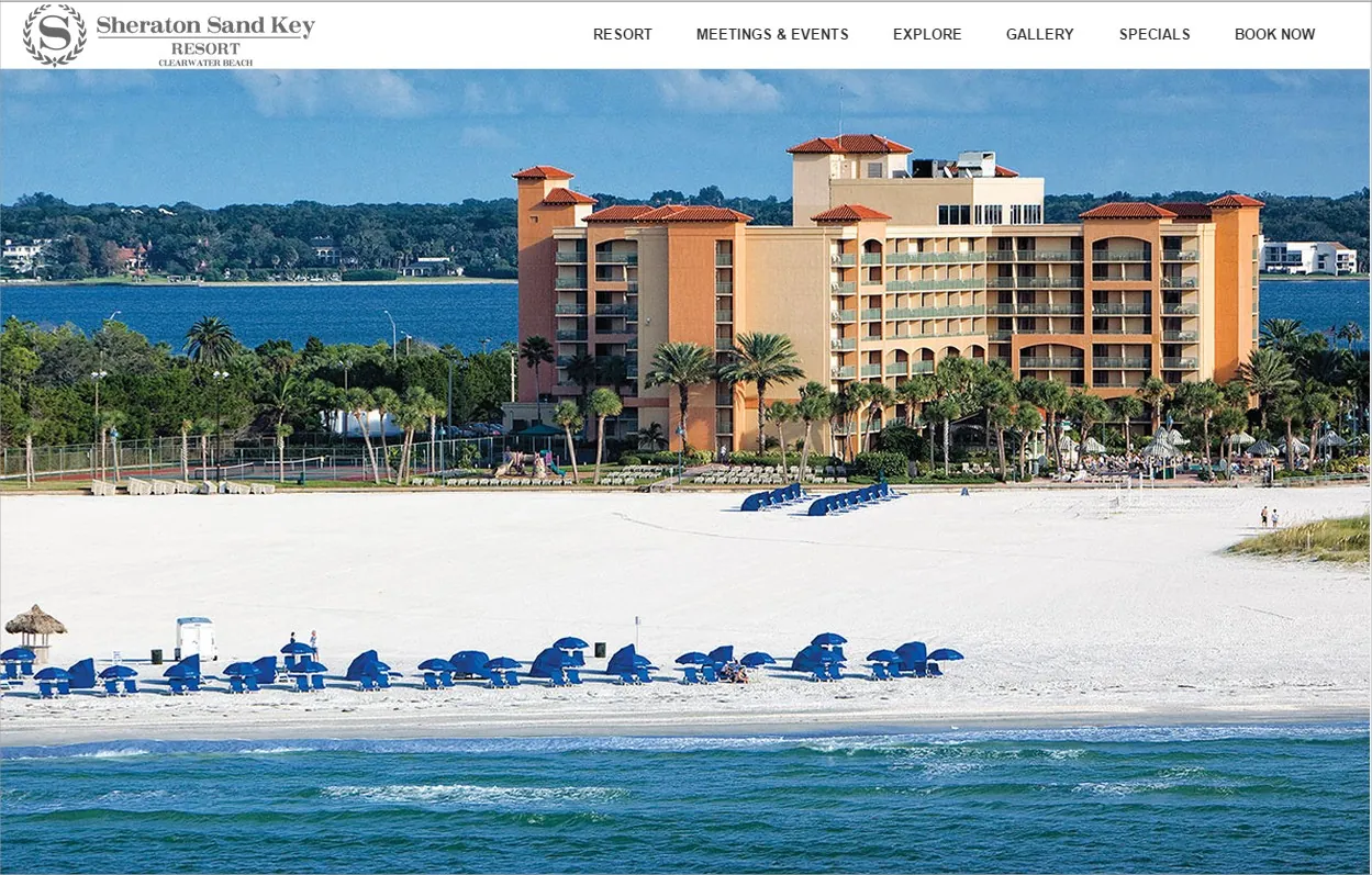Sheraton Sand Key resort website homepage showing a beachfront hotel with blue beach chairs