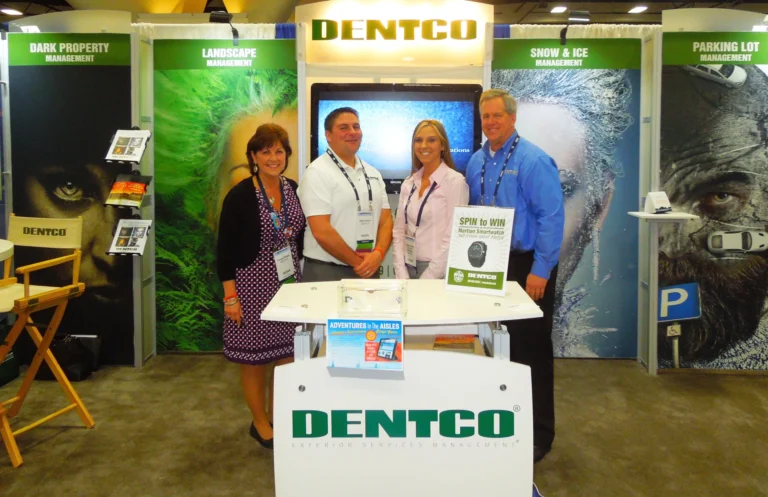 Four people standing at the Dentco trade show booth