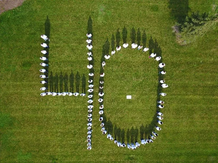 DENTCO celebrates 40 years, aerial view of people forming the number 40 on a lawn