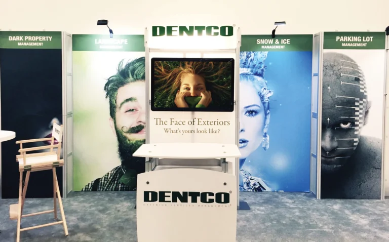 Dentco trade show booth with large face graphics and monitor