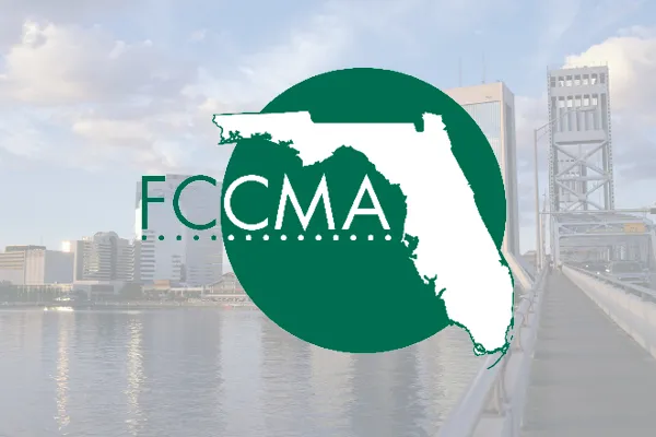 FCCMA logo over a faded waterfront city skyline
