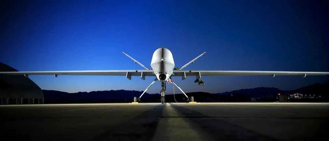 Unmanned military drone aircraft on a runway at dusk