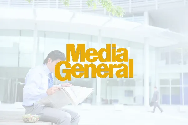 Media General logo over a faded photo of a man reading outside a building