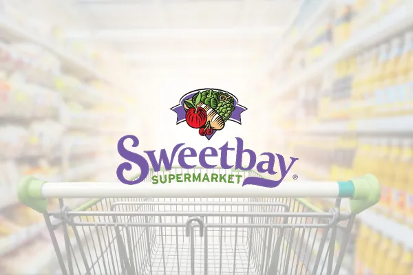 Sweetbay Supermarket logo over a shopping cart in a grocery aisle