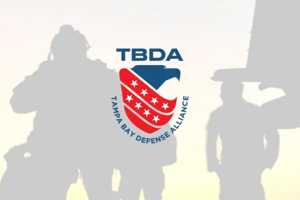 Tampa Bay Defense Alliance TBDA logo over silhouettes of service members
