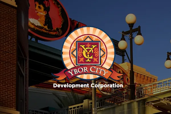 Ybor City Development Corporation logo over a night street scene with lamp posts