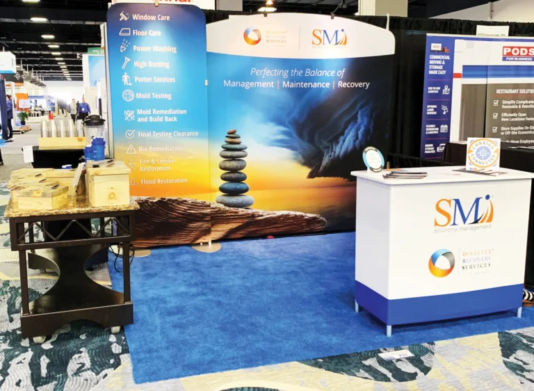 SMI trade show booth with sunset stacked stones backdrop