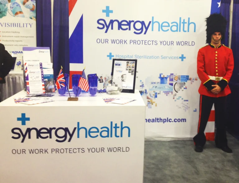 Synergy Health trade show booth with costumed guard