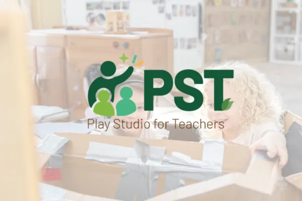 Play Studio for Teachers PST logo faded over a photo of children in a cardboard box