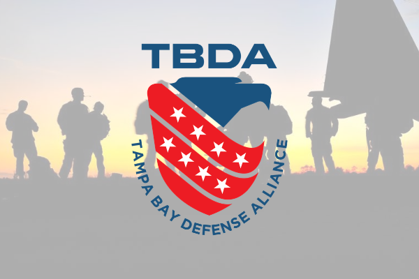 TBDA Tampa Bay Defense Alliance logo over faded soldiers at sunset