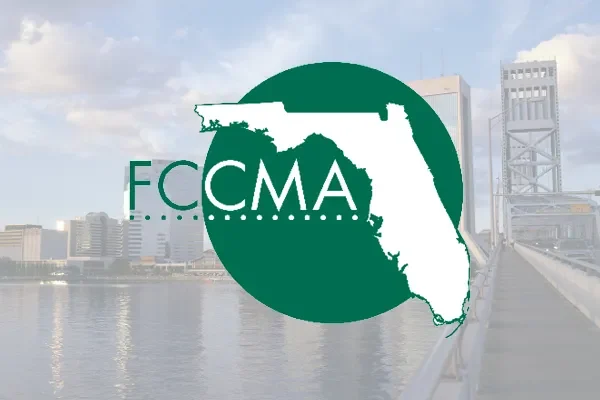 FCCMA logo over a faded waterfront city skyline