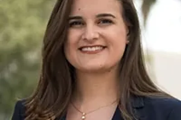 Kristen, smiling woman with long brown hair in a navy blazer