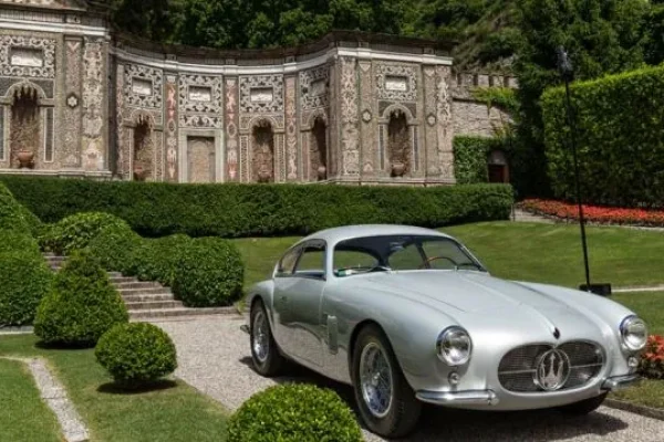 Old Maserati on lawn of nice residence
