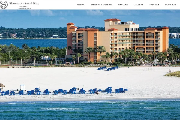 Sheraton Sand Key resort website homepage showing a beachfront hotel with blue beach chairs