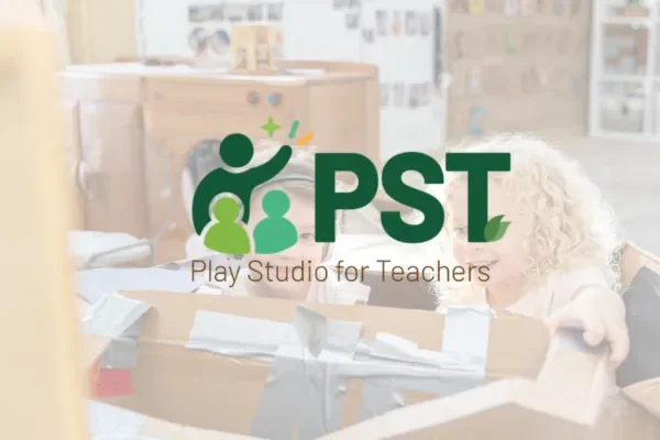 Play Studio for Teachers PST logo faded over a photo of children in a cardboard box