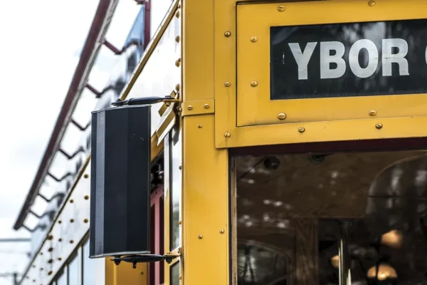 Yellow Ybor City streetcar with a street name sign under a blue sky